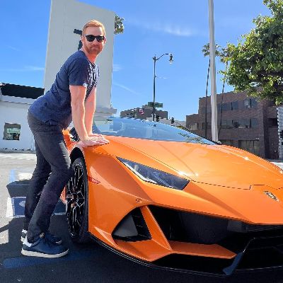 Andrew Santino took a picture with a super car.